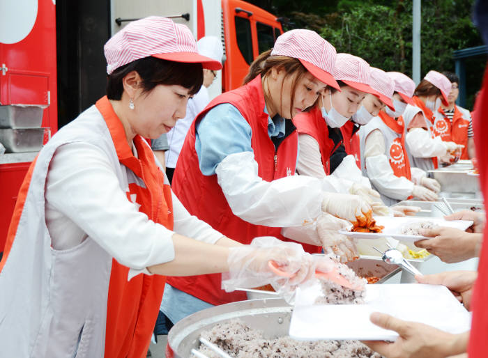 차재연 비씨카드 경영기획총괄부문장(왼쪽)과 KT그룹 임직원 봉사단이 `사랑 나눔 축제`에서 빨간밥차 배식 활동을 했다.