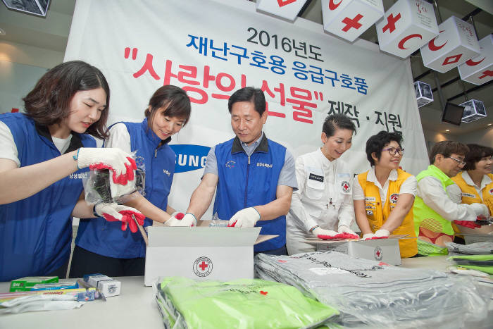 삼성 임직원과 적십자 관계자들이 재난구호용 응급구호품 제작하고 있다. 왼쪽 세번째부터 윤주화 삼성사회봉사단 사장, 김성주 대한적십자사 총재,박찬봉 사회복지공동모금회 사무총장.