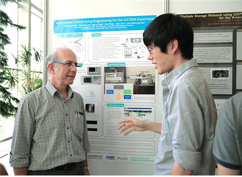 4일 KUSP 2016 성과보고 포스터 전시회가 열린 KAIST 대덕캠퍼스 궁리실험관 1층 로비에서, IBS 액시온 및 극한상호작용 야니스 세메르치디스 연구단장(왼쪽)이 KUSP에 참여한 학생의 설명을 듣고 있다. 야니스 세메르치디스 단장은 “작년과 비교해 우수한 학생들이 참여해 실제 실험물리학을 경험하는 기회를 가졌다. 성공적으로 프로그램을 마쳐 매우 기쁘다”고 말했다.