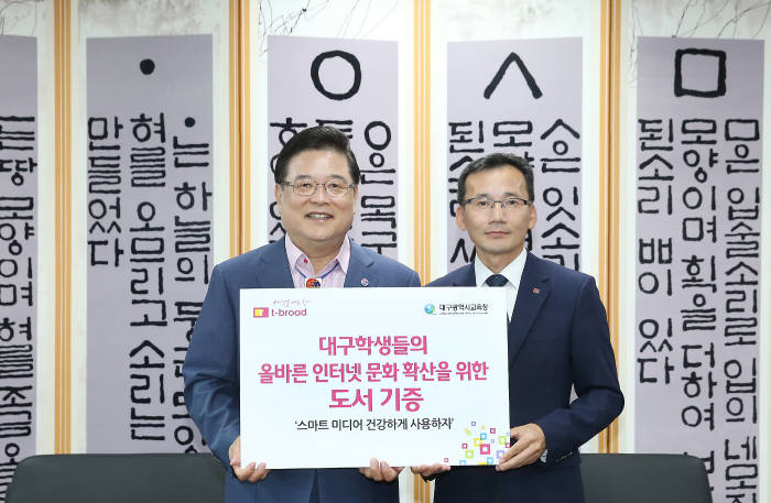 우동기 대구광역시 교육감(왼쪽)과 김상섭 티브로드 대구 사업부장이 도서 전달식에서 기념촬영하고 있다.