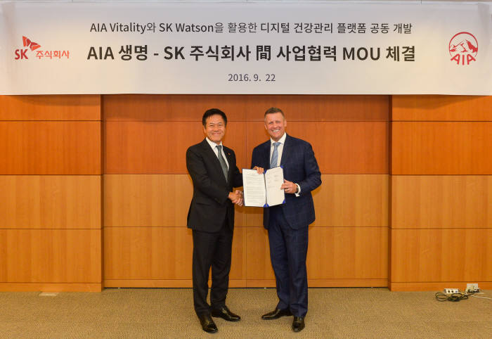 박정호 SK주식회사 사장(왼쪽)과 빌 라일 AIA 지역 총괄 CEO가 협력을 맺고 기념 사진을 찍고 있다.