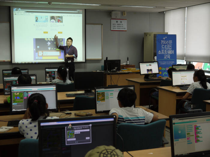 지난달 경기도 분당 SK주식회사 사옥에서 열린 `제1회 드림업 SW교육` 에 참여한 학생들이 로봇 프로그래밍을 위한 사전 교육을 듣고 있다.