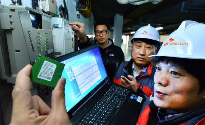SK텔레콤이 `LoRa`망 설치를 확대하고 있다. SK텔레콤 기술진이 1일 서울 장충동 한 건물에서 이동통신 중계기에 `LoRa`망 기술이 적용된 통신모듈을 설치하고 있다. 윤성혁기자 shyoon@etnews.com