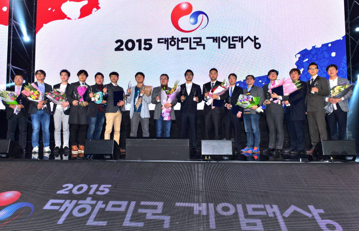 `2015 대한민국 게임대상` 시상식이 2015년 11월 11일 부산 벡스코 그랜드볼룸에서 열렸다. 대상을 수상한 레이븐의 유석호 넷마블에스티 대표(가운데)와 전체 수상자가 기념 촬영하고 있다. `2015 대한민국 게임대상` 시상식에서 대상을 수상한 유석호 넷마블에스티 대표가 수상 소감을 말하고 있다. 윤성혁기자 shyoon@etnews.com