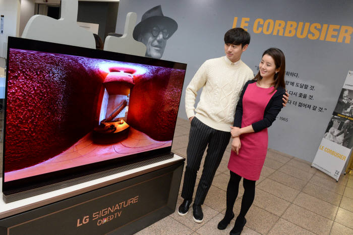 : LG전자가 예술의전당 한가람디자인미술관에서 열리는 `르 코르뷔지에展`에 LG SIGNATURE(LG 시그니처) 올레드 TV 를 설치해 르 코르뷔지에의 주요 건축물, 스케치, 다큐멘터리 등을 생생하게 소개한다. 관람객들이 르 코르뷔지에의 건축물 영상을 보고 있다.