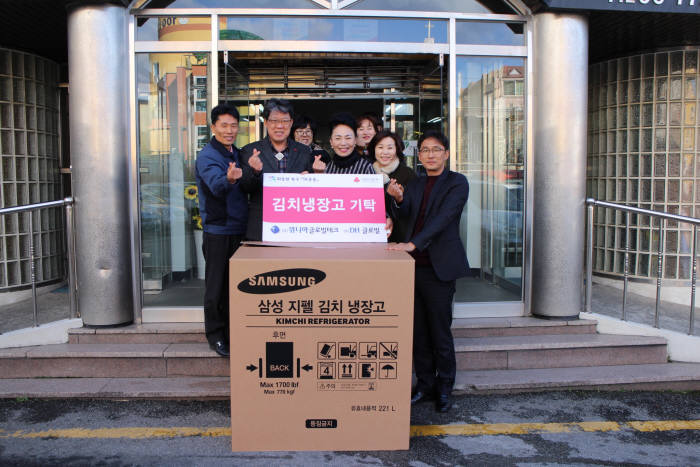 위니아글로벌테크 직원들이 무료급식 시설에 김치냉장고 기증하고 있다.