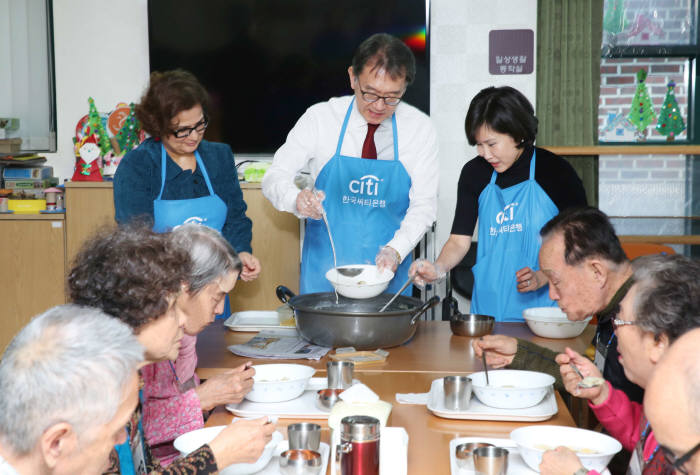 박진회 한국씨티은행장(가운데)가 2일 혜화동성당 데이케어센터를 찾아 어르신들에게 떡국을 배식했다.