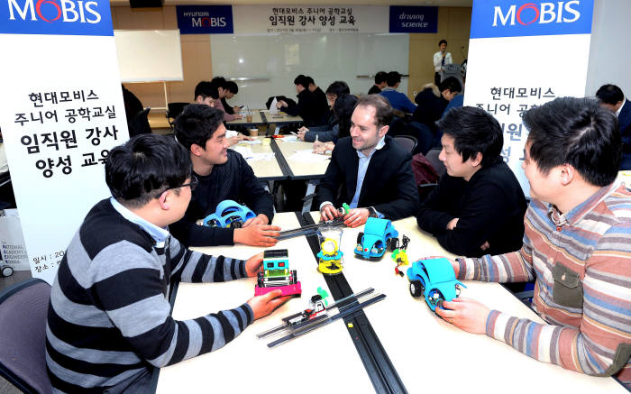 아산 캠코 인재개발원에서 현대모비스 직원 주니어공학교실 강사들이 한국공학한림원과 한양대 청소년과학기술진흥센터 소속 강사진들의 지도 하에 어린이 과학 교보재를 사전 실습하고 있다. (제공=현대모비스)