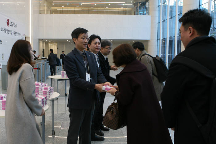 박종석 LG이노텍 사장(왼쪽 두 번째)이 본사 이전 후 첫 출근하는 직원들에게 기념떡과 악수를 건네며 격려하고 있다 <LG이노텍 제공>