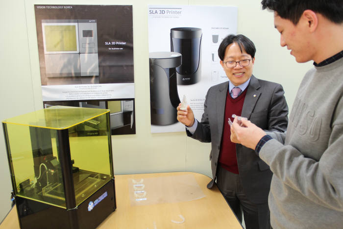 박지종 비즈텍코리아 대표(왼쪽)가 3D 프린터로 제작한 투명 치아 교정기를 살펴보고 있다.