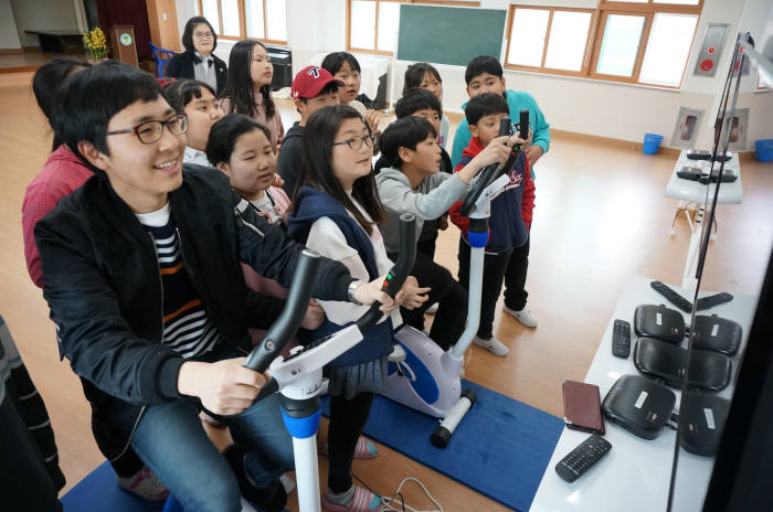 김성용 임자남초등학교 교사(왼쪽 첫번째)가 박영찬 군(임자초 6학년)과 VR 자전거로 대결을 벌이고 있다.