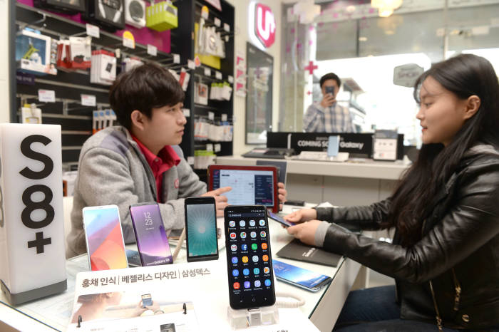 LG유플러스 이촌점에서 고객이 갤럭시 S8과 LG G6 등의 스마트폰 가입 설명을 듣고 있다. 박지호기자 jihopress@etnews.com