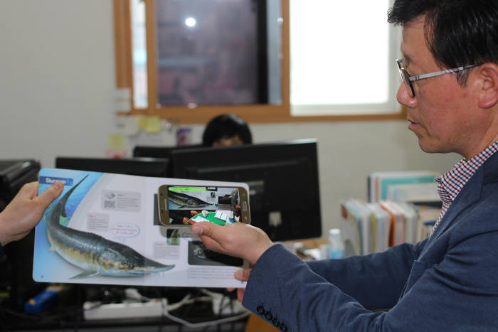 김상국 한울네오텍 부사장이 AR북을 스마트폰으로 시연해 보이고 있다.