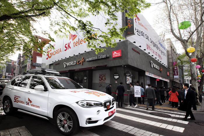종각 T월드 매장 외부 전경. 건물 전체가 갤럭시S8 행사 테마와 SK텔레콤 슬로건(Welcome to 5G Korea) 이미지로 랩핑(Wrapping)된 모습. 1층 매장 옆에 전시된 차량은 SK텔레콤이 자체 개발한 커넥티드카 'T5'. 이날 보신각 옆 종각 T월드 매장 건물은 도심 속 갤럭시S8 랜드마크로 탈바꿈했다.