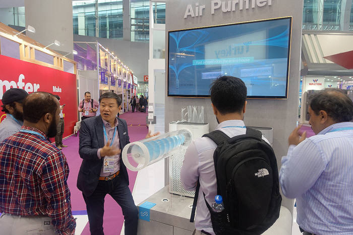 코웨이 '2017 캔톤 페어' 부스에서 김용성 코웨이 해외사업본부장(오른쪽에서 세 번째)이 전시회 참관객들에게 깨끗한 공기 흐름을 만드는 멀티액션 공기청정기 제품에 대해 설명하고 있다.