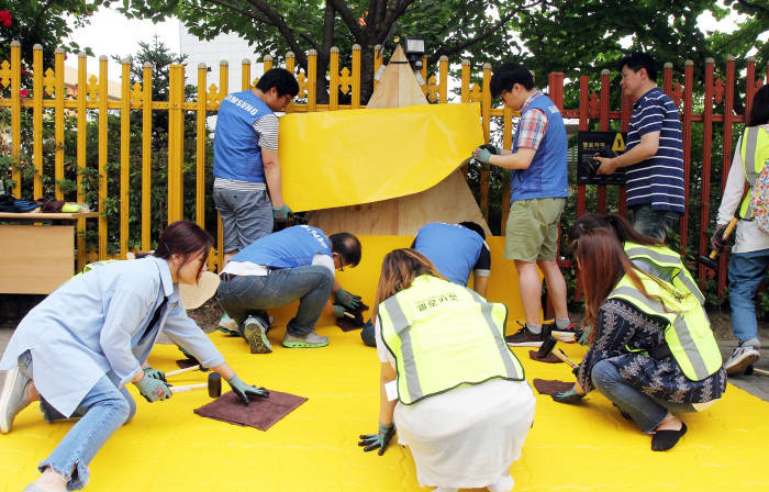 삼성전자 임직원 봉사자와 용인초등학교 학부모들이 아이들의 안전한 통학을 위해 학교 인근 횡단보도 앞에 '옐로카펫'을 설치했다.