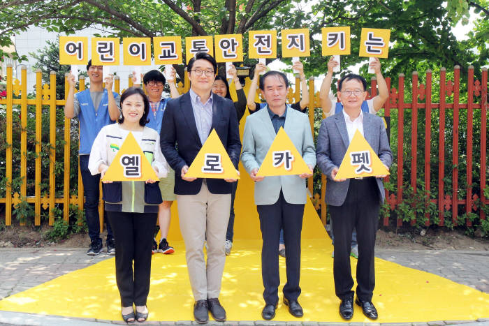 용인초등학교 인근 횡단보도에 '옐로카펫'을 설치한 후 관계자들이 기념촬영을 하고 있다.