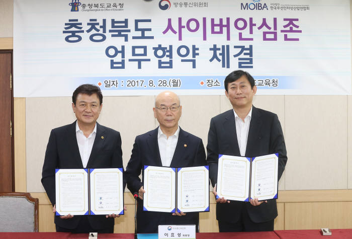 방송통신위원회는 충청북도교육청, 한국무선인터넷산업연합회와 충북 지역 초·중·고교 학생의 스마트폰 과몰입과 인터넷 유해정보 노출 예방을 위한 '사이버안심존' 서비스 업무협약을 28일 체결했다. 김병우 충북교육청 교육감, 이효성 방통위 위원장, 고진 MOIBA 회장(왼쪽부터)이 기념촬영을 하고 있다.