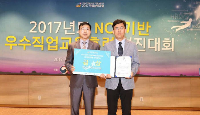 영진전문대학이 7일 서울 코엑스 컨퍼런스룸에서 열린'NCS기반 우수 직업교육훈련 경진대회 우수사례 발표심사 및 시상식'에서 노동부장관상인 금상을 수상했다. 사진은 컴퓨터응용기계계열 사례를 발표한 이대섭 교수(오른쪽)가 금상을 받고 기념촬영하고 있다.