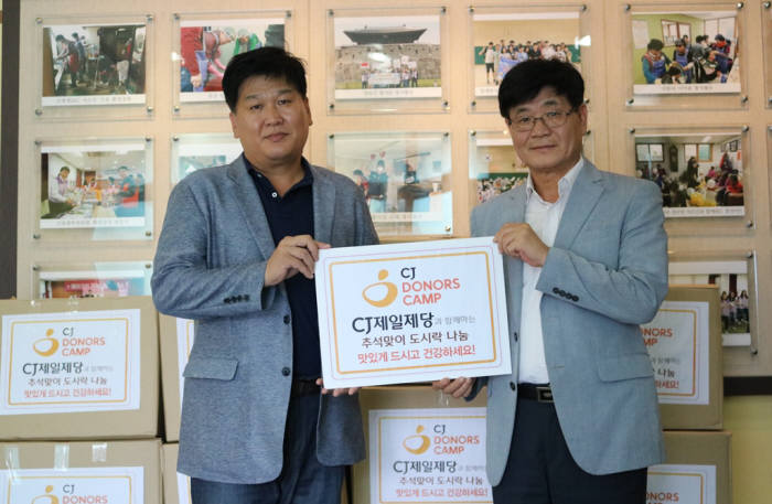 박충일 CJ제일제당 기업외식SU장(왼쪽)과 이종두 중구 자원봉사센터장이 소외계층에게 전달할 명절음식을 전달 받은 후 기념촬영했다.