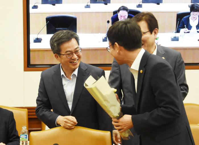 김동연 경제부총리 겸 기획재정부 장관(왼쪽)이 김상조 공정거래위원장과 경제관계장관회의에 앞서 인사하고 있다.