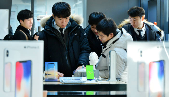 수능이 끝난 첫 주말 휴대폰 제조사와 이동통신사가 각종 프로모션을 실시하며 가입자 유치전에 뛰어들었다. 주말 서울 광화문 KT스퀘어를 찾은 학생들이 스마트폰을 살펴보고 있다. 윤성혁기자 shyoon@etnews.com