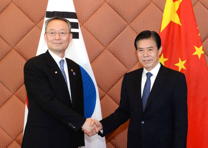 지난 15일 중국을 방문한 백운규 산업통상자원부 장관(왼쪽)이 중산 중국 상무부 부장과 만나 악수하고 있다.