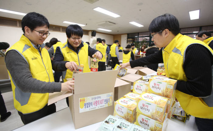 25일 서울 서대문구 남가좌동에 위치한 서대문종합사회복지관을 찾아 보리차와 김, 햄 및 각종 밑반찬 등으로 구성된 식료품세트를 기부하는 봉사활동을 펼쳤다. 동서식품 임직원들이 서대문종합사회복지관에서 식료품세트를 포장하고 있다.