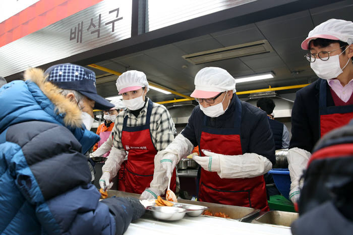 12일 '제 3회 롯데면세점과 함께하는 따뜻한 집밥 나눔' 행사에서 롯데면세점 장선욱 대표이사(가운데), 김금주 노조위원장(왼쪽), 김주남 지원부문장(오른쪽)이 배식 봉사활동을 진행하고 있다.