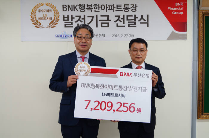 BNK부산은행이 27일 발전기금 전달 대상 아파트를 대표해 LG메트로시티 아파트 관리사무소에 700만원 상당 발전기금을 전달했다. 손강 BNK부산은행 남부영업본부장 상무(오른쪽)가 기념촬영을 하고 있다.