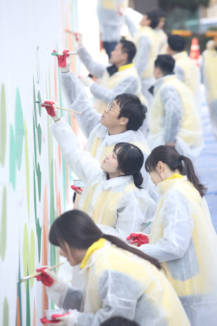 동서식품은 22일 서울 마포구 도화동에 위치한 마포초등학교를 방문해 안전하고 깨끗한 거리 조성을 위한 벽화그리기 봉사활동을 진행했다. 동서식품 임직원들이 담벼락에 벽화를 그리고 있다.