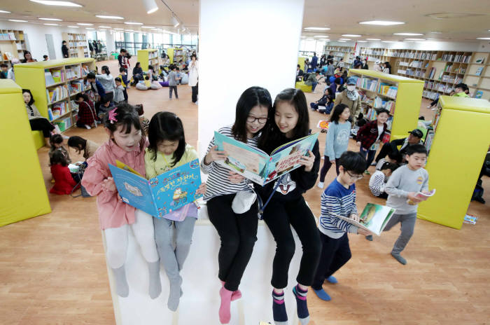 용인국제어린이도서관 책놀이터에서 어린이들이 책을 보고 있다.