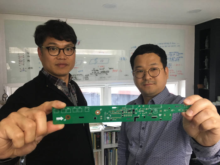 PCB디자인업체 지로이아이가 PCB 제조원가를 대폭 낮출 수 있는 기술을 개발했다. 이 회사의 이한수 대표(오른쪽)과 민경환 이사가 크로스모듈(검은 부품)을 적용한 PCB를 보여주고 있다.