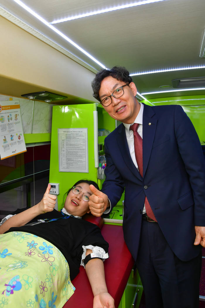 지난 13일 서울시 중구 농협은행 본점에서 진행된 '생명사랑 헌혈봉사' 행사에서 이대훈 농협은행장(오른쪽)이 헌혈중인 직원을 찾아가 격려했다.