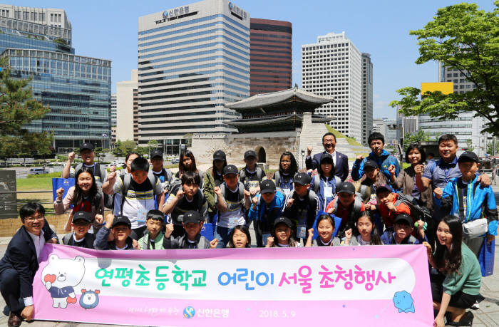 9일 신한은행 관계자들과 연평초등학교 어린이들이 '한양도성원정대' 프로그램을 마치고 숭례문 앞에서 함께 화이팅을 외치는(기념촬영 하는) 모습