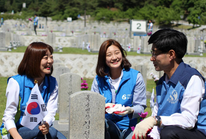 신한은행 임직원과 가족 430여명은 19일 서울 동작구 소재 국립 현충원에서 자원봉사를 실시했다. 임직원들이 자원봉사 활동 중 환하게 웃고 있다.