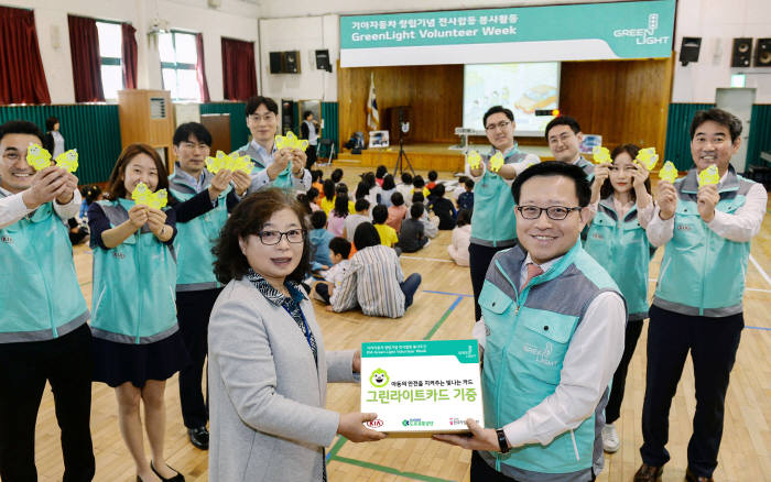 곽용선 기아차 경영전략실장(오른쪽)과 강경옥 반원초등학교 교감선생님(왼쪽)이 '그린 라이트 카드' 전달을 기념해 포즈를 취하고 있다.