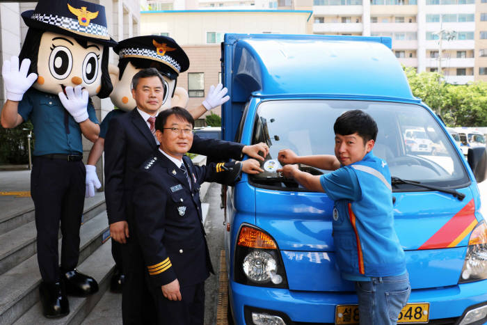 김홍근 동대문경찰서장과 진상훈 CJ대한통운 상무가 이재황씨 택배차량에 '포돌이 안심택배' 인증 스티커를 부착했다.