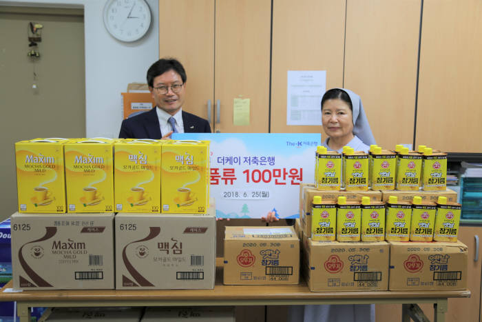 배재환 더케이저축은행 대표(왼쪽)가 성북푸드마켓에 100만원 상당의 식품류를 전달한 뒤 기념사진을 촬영했다.