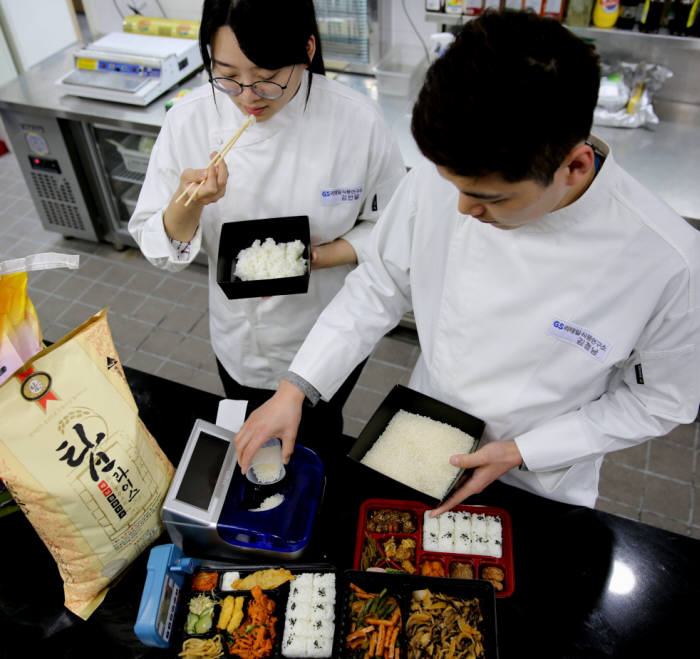 GS리테일 식품연구소 연구원들이 쌀 품질을 판별하는 기기와 탑라이스로 지은 밥으로 테스트를 진행하고 있다.