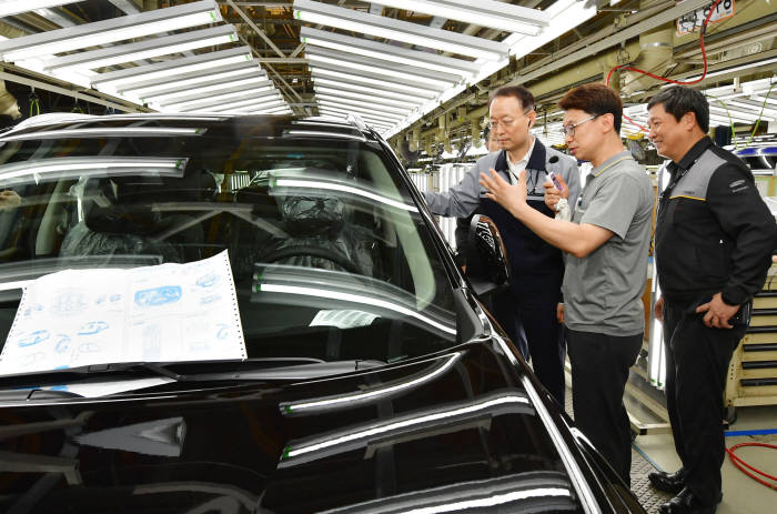 백운규 산업통상자원부 장관(왼쪽)이 르노삼성차 부산공장 생산라인을 둘러보고 있다.