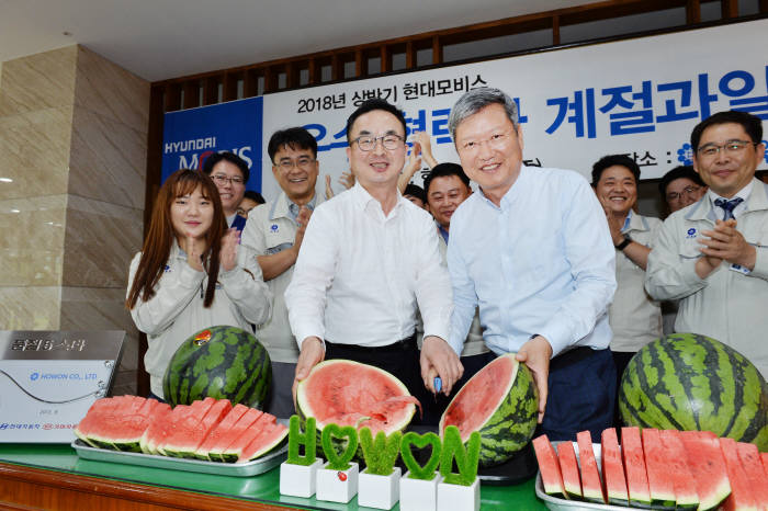 현대모비스가 우수 협력사와 대리점에 수박 1만 통과 감사장을 전달했다. 광주광역시 소재 호원에서 김대곤 현대모비스 구매지원담당 상무(앞줄 왼쪽)와 양진석 호원 대표(앞줄 오른쪽)가 수박을 나누며 상생 결의를 다지고 있다.