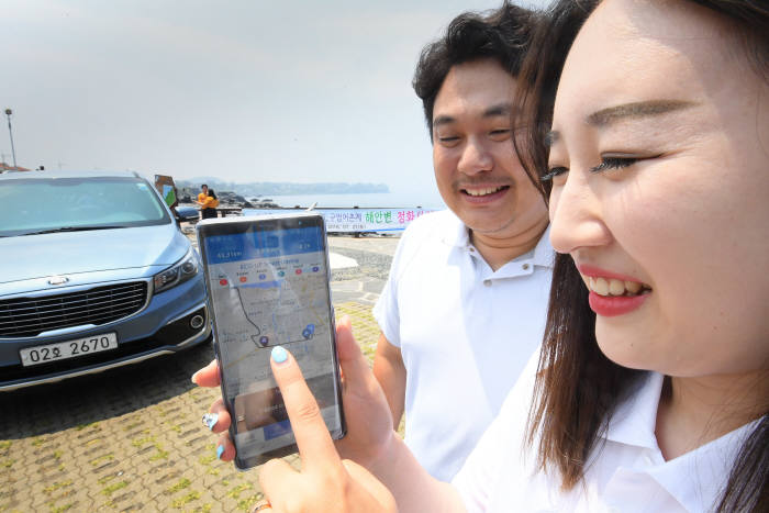 커넥티크 렌터카를 빌린 고객이 ODB(운행기록자기진단장치)와 연동한 모바일 앱을 통해 실시간 운행정보를 확인하고 있다. 제주= 이동근기자 foto@etnews.com