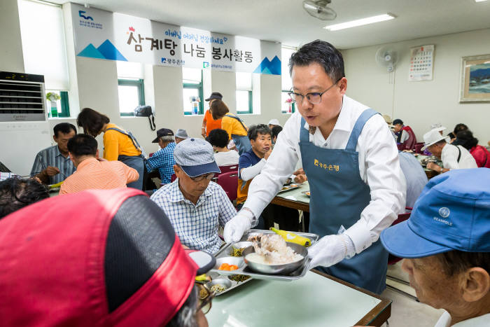 송종욱 광주은행장(오른쪽 두 번째)이 20일 광주 남구 지역 어르신에게 삼계탕을 배식하고 있다.