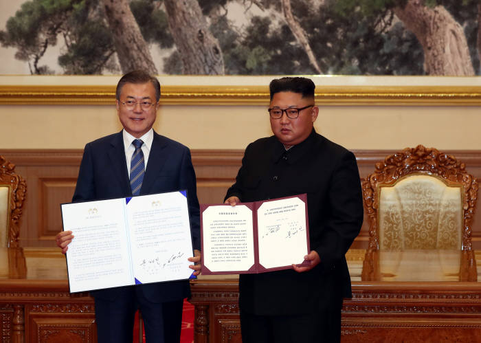 문재인 대통령과 김정은 국무위원장이 19일 백화원 영빈관에서 정상회담을 마친 뒤 평양공동선언서에 서명한 뒤 펼쳐 보이고 있다. <평양사진공동취재단>