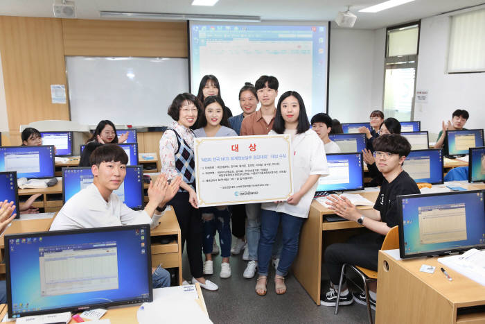 단체부문 대상인 기획재정부 장관상에 오른 전산세무회계전공반(스마트경영계열)학생들이 대학 강의실에서 지도교수(왼쪽)와 함께 기념촬영을 하고 있다.