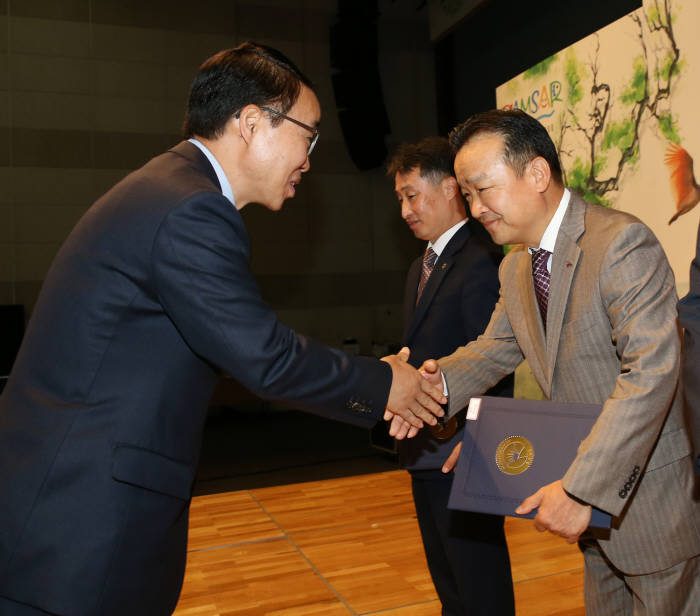 한기환 BNK경남은행 상무(오른쪽부터)가 경상남도 박성호 행정부지사로부터 유공자(기업) 표창을 받고 있다.