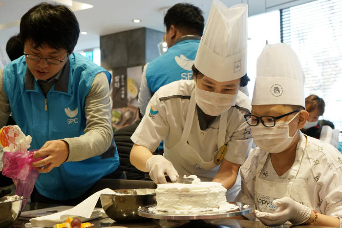 SPC그룹 임직원들이 연세암병원 소아암 어린이들과 케이크를 만들고 있다.