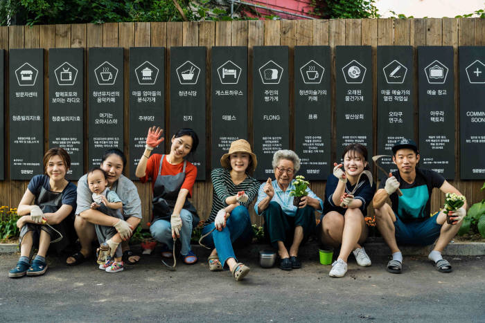 마을주민과 입주청년들이 봉사활동 중 기념사진을 찍는 모습.