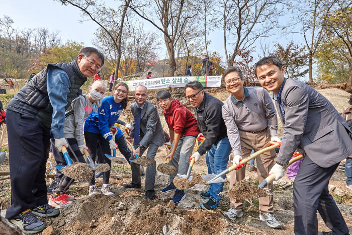 금호타이어가 서울 홍은동 북한산에서 서울시와 함께 탄소 상쇄 숲 행사를 진행했다. 행사 참가자들이 나무를 심고 있다.